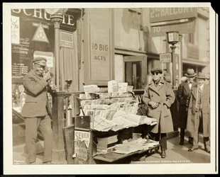 Marchand de journaux aveugle, John Lanz, à son stand au coin nord-est de la 7e Avenue et de la 47e Rue, New York, 1926 (tirage gélatino-argentique)